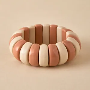 Detail of macaron resin elastic bracelet with cream and red rectangular beads