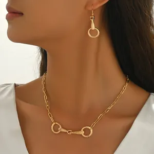 Elegante conjunto de collar y pendientes dorados con diseño geométrico de bocado de caballo