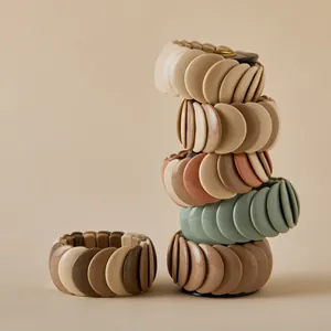 Fashionable macaron earth tone wide resin bracelets stacked in a minimalist arrangement