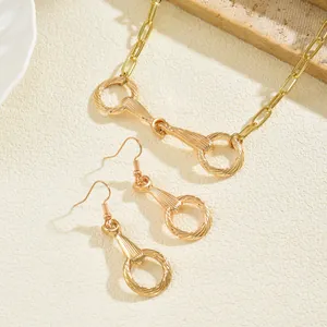 Conjunto de joyas geométricas doradas con collar de bocado y pendientes a juego