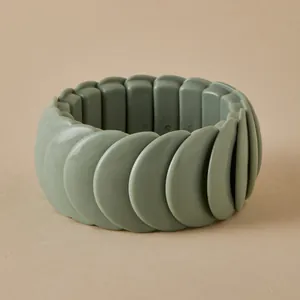 Macro shot of bean green matte resin bracelet showing flexible elastic band and tiered beads
