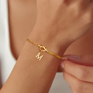 Gouden Cubaanse schakelarmband met knoop en zirkoon ingelegde letter M hanger voor dames