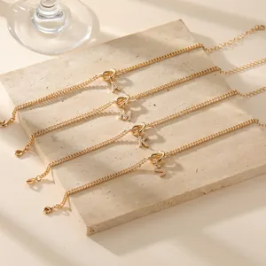 Gouden armband met alfabetletter en zirkoon op een minimalistische stenen basis