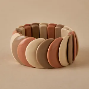 Close-up of chunky stretch bracelet with earth-toned resin segments in a minimalist style