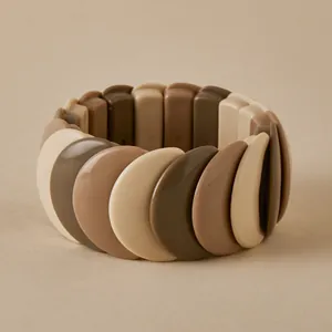 Macro shot of wide elastic bangle featuring nude tone crescent resin pieces
