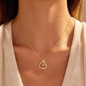 Detail of gold heart pendant necklace with micro-paved zirconia letter A on a model