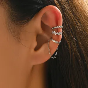 Gros plan de trois ear cuffs argentés avec cristaux et longue chaîne pendante