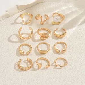 Flat lay of 12-piece gold geometric ring set including pearl and lava style designs