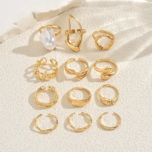 Detailed set of twelve gold-plated geometric rings featuring a large white baroque pearl