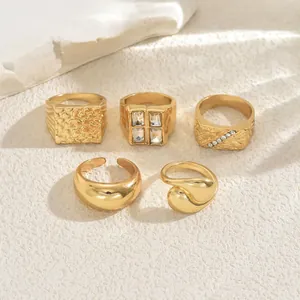 Detail of 5-piece gold ring set featuring geometric textures and zircon stones