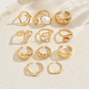 Detailed flat lay of 11 gold rings set with elegant pearls and textured metal designs