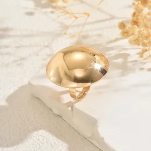 Detailed view of an elegant gold dome ring with a polished finish on a stone pedestal