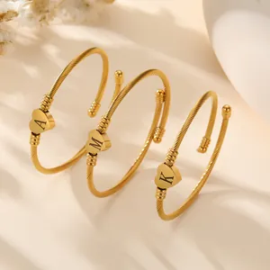 Elegant gold twisted cable bangle with heart-shaped initial charms A, M, and K