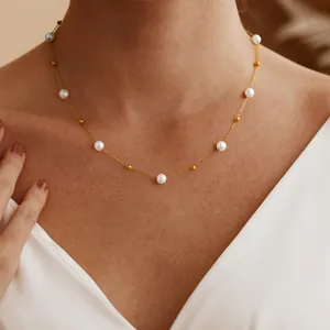 Nahaufnahme einer eleganten Goldkette mit Perlen auf dem Hals eines weiblichen Models