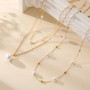 Elegantes Perlenhalsketten-Set in Gold mit Anhänger auf weißer römischer Säule