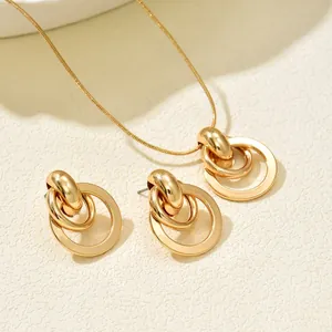 Golden jewelry set featuring minimalist double-ring pendant necklace and stud earrings