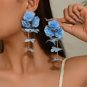Close-up of elegant light blue chiffon floral drop earrings worn by a model