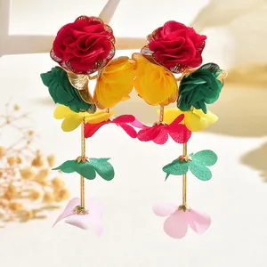 Detailed close-up of multi-layered fabric floral drop earrings with gold metallic stems