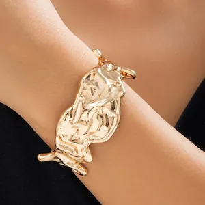 Golden liquid metal cuff bracelet featuring irregular texture and modern design