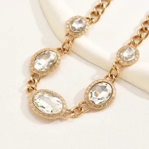 Luxurious gold chain necklace with large oval crystals and pavé diamonds on white background
