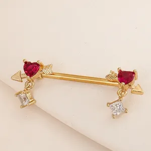 Close-up of gold nipple bar featuring red heart stones and square zircon pendants