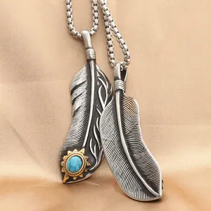 Colgante pluma punk retro de acero inoxidable con piedra turquesa sobre seda dorada