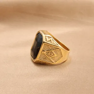 Detail of vintage gold-tone ring featuring a large rectangular black gemstone and masonic emblem