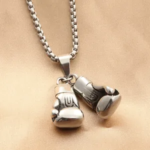 Polished stainless steel boxing glove pendant with box chain on gold silk fabric