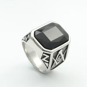 Macro shot of silver titanium steel ring with rectangular black gemstone and Masonic logo