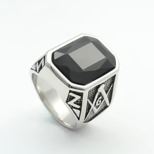 Detailed macro view of silver steel ring featuring rectangular black gemstone and masonic emblem