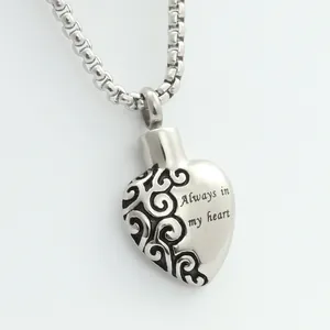 Macro shot of silver heart pendant with Always in my heart engraving and retro scrolls