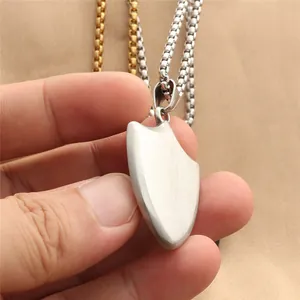 Macro shot of punk shield pendant in brushed stainless steel with box chain necklace