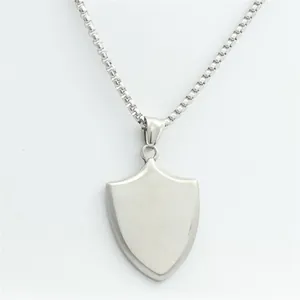 Close-up of a silver shield pendant with brushed texture on a box chain necklace