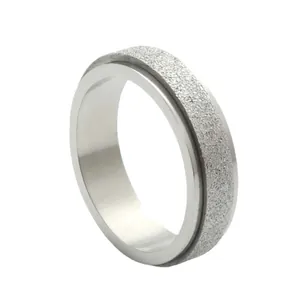 Macro shot of silver spinner ring with frosted star texture and polished inner steel band