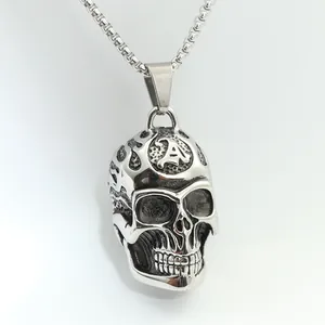 Makroaufnahme von Vintage-Totenkopfanhänger mit gotischem A-Buchstaben und Flammenrelief