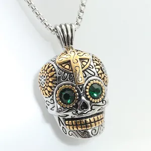 Detailed macro view of a silver skull pendant with gold cross and green gemstone eyes
