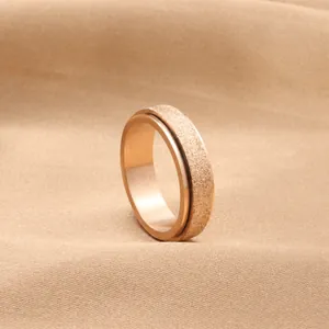 Macro detail of rose gold rotating stress relief ring with frosted surface texture