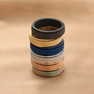 Close-up of matte textured stainless steel rings in assorted metallic colors and finishes