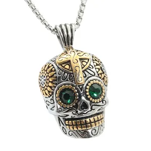 Punk style stainless steel skull pendant with green gemstone eyes and gold cross accent