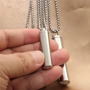 Macro detail of polished stainless steel cylinder pendant with classic ball chain necklace