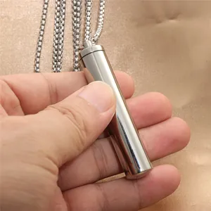 Polished stainless steel cylinder pendant necklace on champagne silk fabric background