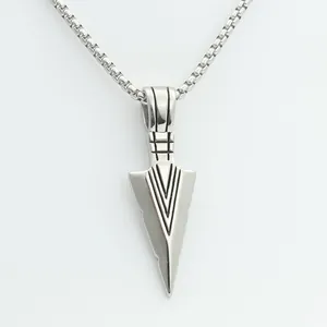 Detailed view of silver spearhead pendant with geometric engraving and sleek box chain