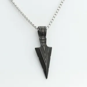 Macro detail of punk spearhead pendant with geometric engraving and silver box chain