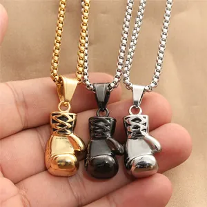 Makroaufnahme von Boxhandschuh-Anhängern aus Edelstahl in Gold, Silber und Schwarz