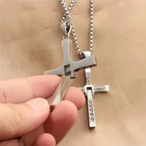 Detailed close-up of a silver stainless steel cross pendant with a mechanical joint feature
