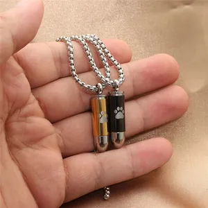 Close-up of gold and black bullet pendants with paw prints on silk background