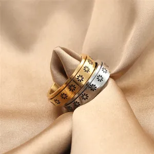 Close-up of rotatable punk style rings with black daisy pattern on champagne satin