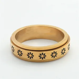 Detailed macro view of the gold spinner ring featuring black daisy floral patterns