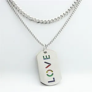 Makroaufnahme einer doppelten Edelstahlkette mit regenbogenfarbenem LOVE-Anhänger
