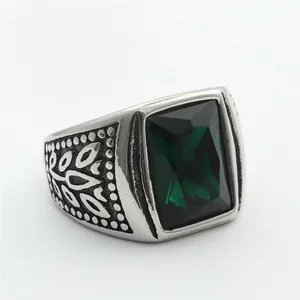 Macro shot of retro stainless steel ring featuring a square emerald-cut green gemstone